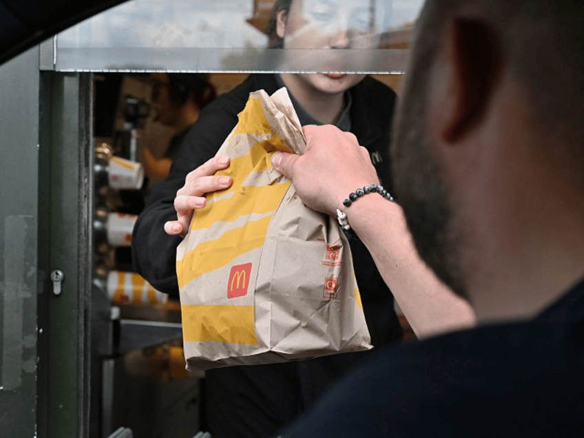 BASILDON, ENGLAND - MAY 25: A driver collects a McDonald's order at a drive-through restau