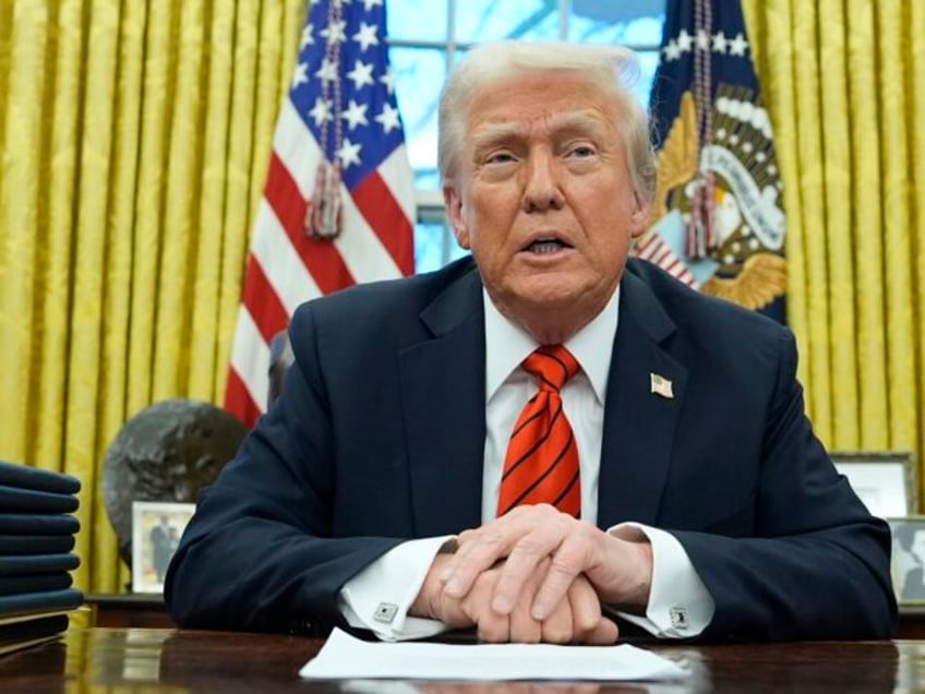 President Donald Trump speaks with reporters as he signs an executive order in the Oval Of