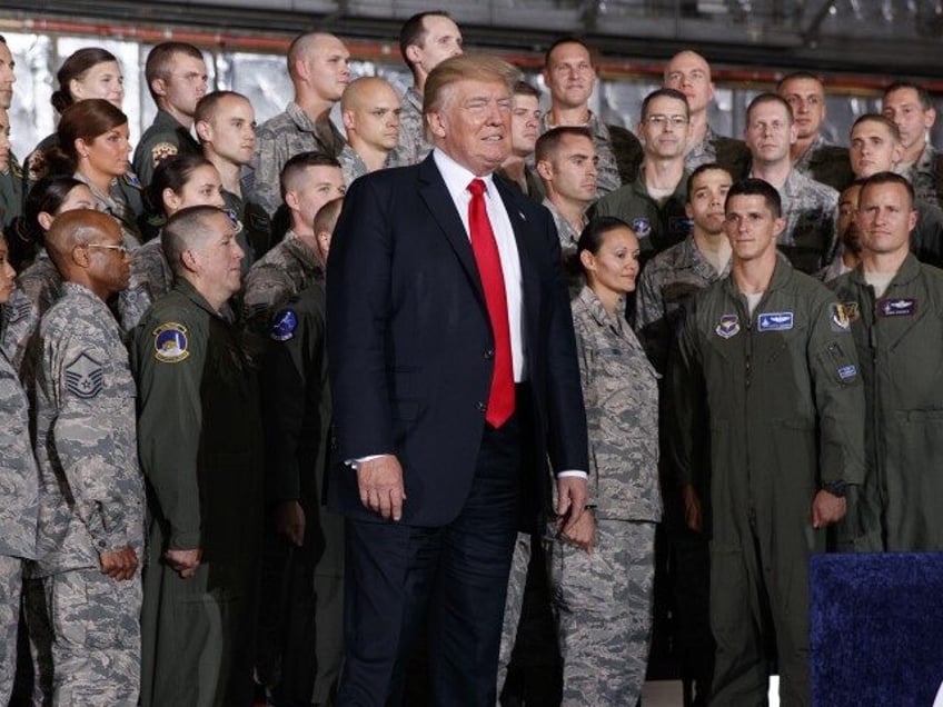 President Donald Trump listens as he is introduced by first lady Melania Trump to speak to