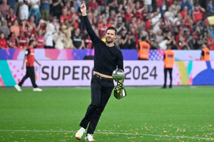 Bayer Leverkusen coach Xabi Alonso with the DFL Super Cup after his side won on penalties