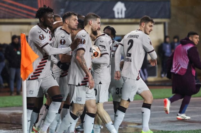 Bayer Leverkusen players celebrate their late equaliser against Qarabag to maintain their