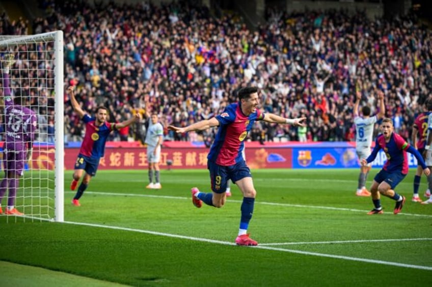 Barcelona's Polish forward Robert Lewandowski (C) celebrates after scoring against Alaves