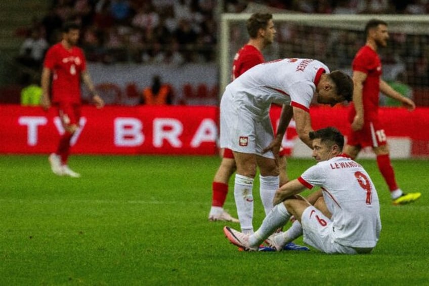 Polan captain Robert Lewandowski sits on the pitch before leaving the game against Euro wa