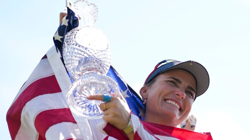 Lexi Thompson smiles with American Flag on shoulders