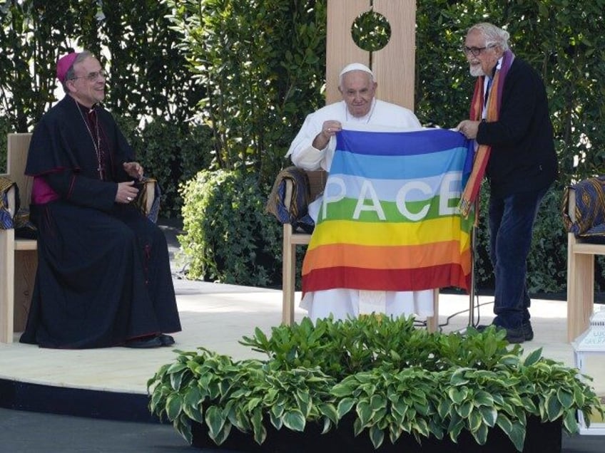 Pope Francis is offered a peace flag by father Alex Zanotelli, right, during the "Are