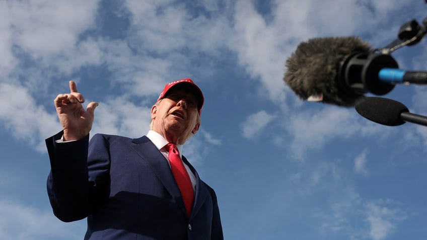 Donald Trump talks to reporters after watching the Daytona 500