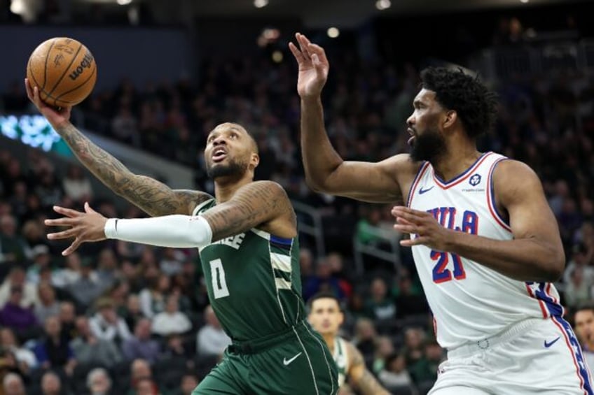 Damian Lillard of the Milwaukee Bucks drives to the basket against Joel Embiid in the Buck