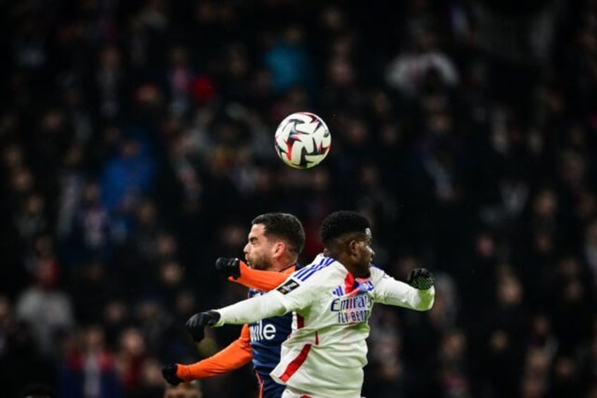 Lyon's Ghanaian forward Ernest Nuamah (R) fights for the ball with Montpellier midfielder