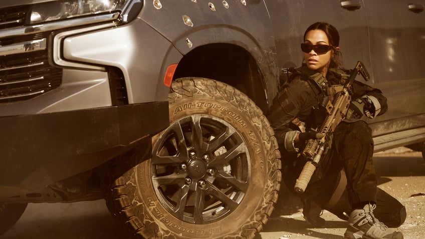 Zoe Saldana in Lioness holding a gun