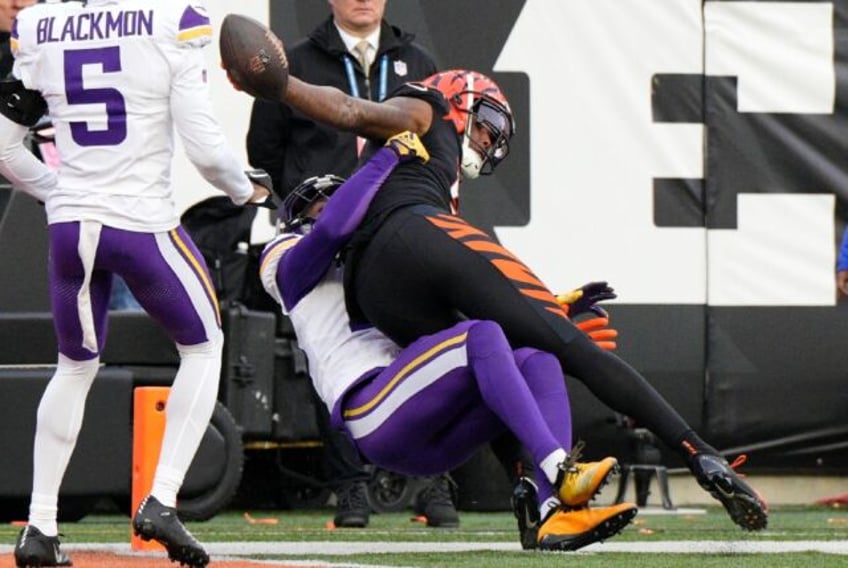 Cincinnati's Tee Higgins swings the ball over the goal line for a dramatic tying touchdown in the final seconds of regulation time during the Bengals' overtime NFL victory over Minnesota