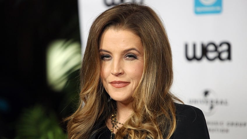 Lisa Marie Presley in black attire looks semi-serious on the carpet at the NARM Music Biz Awards Dinner Party