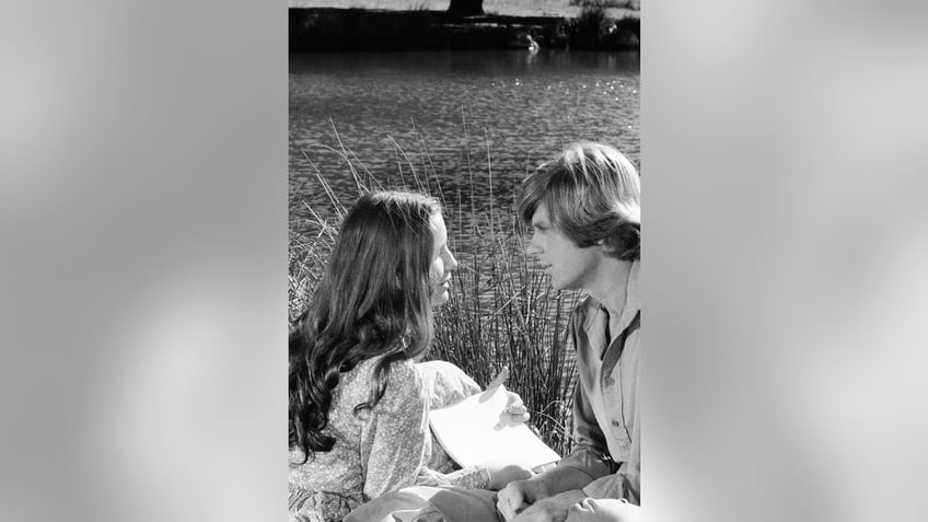 Melissa Gilbert looking admiringly at Dean Butler in a field