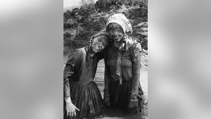 Melissa Gilbert and Alison Arngrim muddied up and hugging each other
