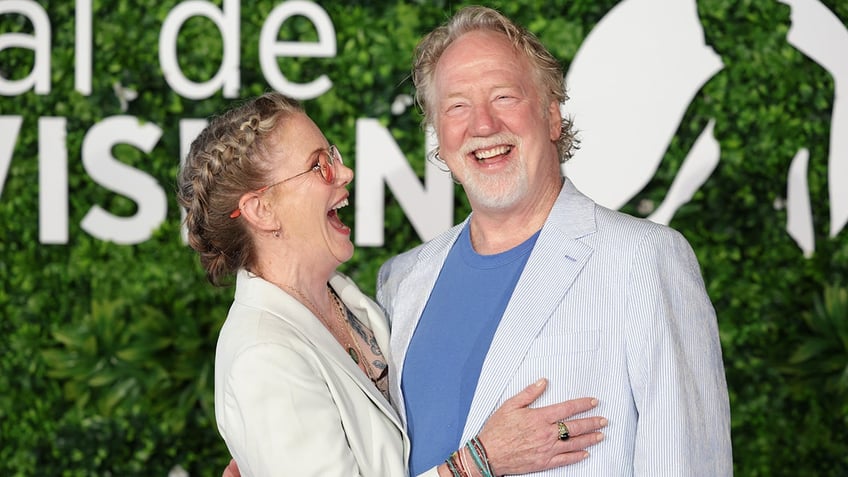 Melissa Gilbert laughing and holding onto her husband.