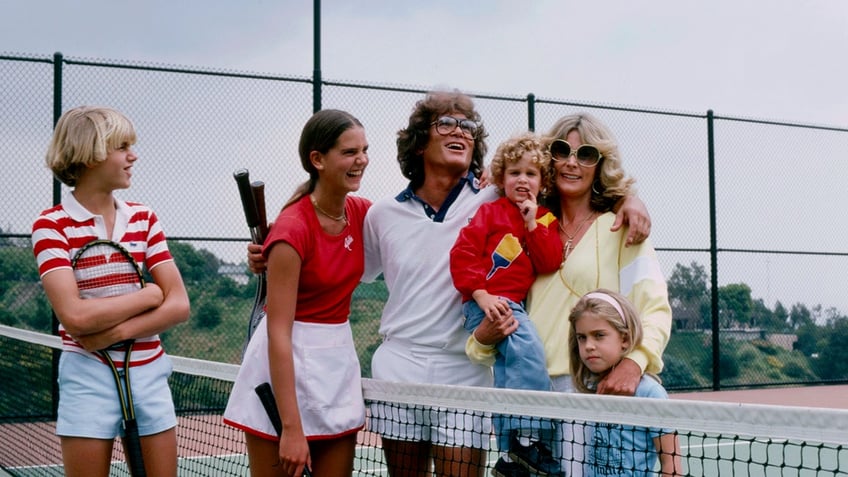 Michael Landon surrounded by his children in a tennis court