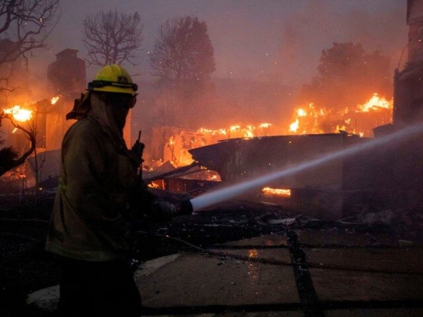 A firefighter battles the blaze on El Medio Avenue during the Palisades Fire in the Pacifi