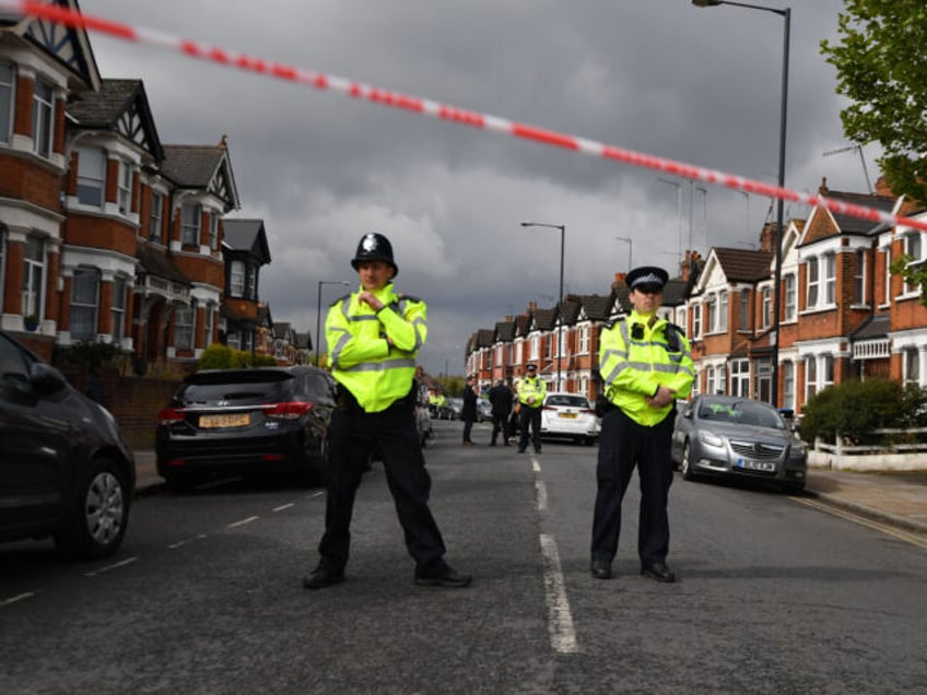 TOPSHOT - British police officers secure a cordon in a residential street in north-west London on April 28, 2017 where firearms officers shot a female subject after they carried out a specialist entry into an address as part of a Counter Terrorism investigation the previous day. - British police warned …