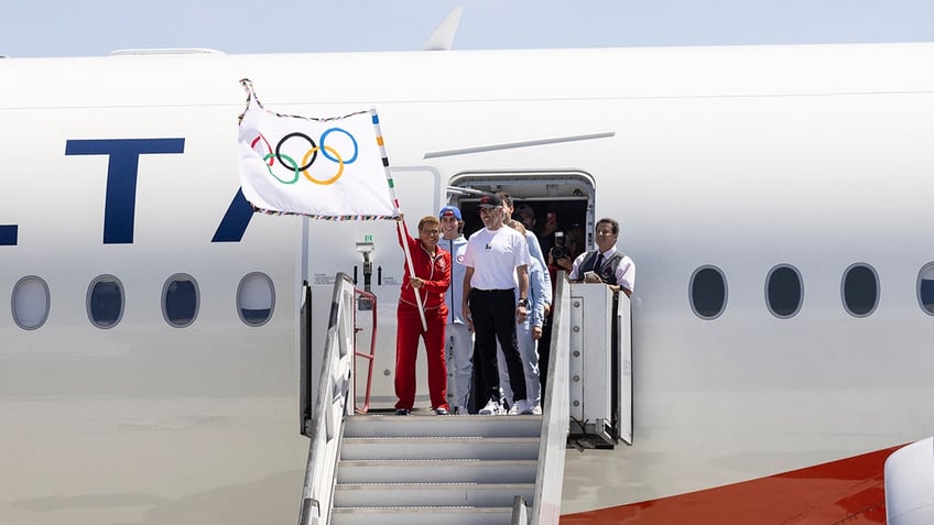 Karen Bass waves Olympic flag on plane