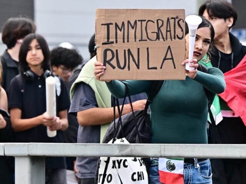 A person holds a sign as hundreds of high school students participate in a protest entitle