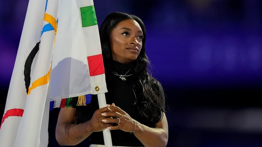 Simone Biles holds the flag