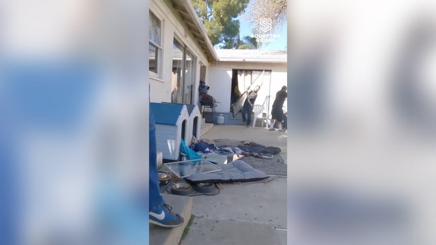 Clutter on the side of a house invaded by squatters