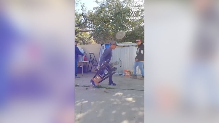 Man dragging items down a driveway in San Fernando Valley