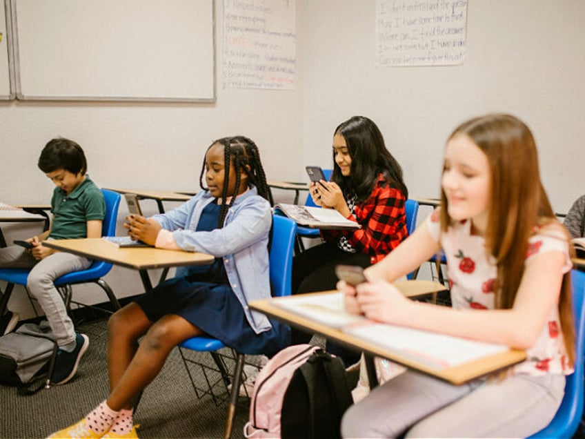 Students Sitting Inside the Classroom While Using Their Smartphone