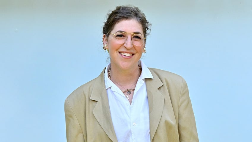 Mayim Bialik smiles on the red carpet.