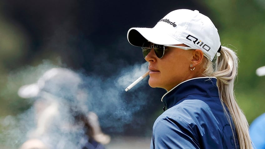Charley Hull puffs on a cigarette