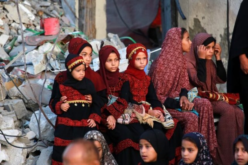 Palestinians, some in traditional embroidered dresses, gather on Eid al-Adha in southern G