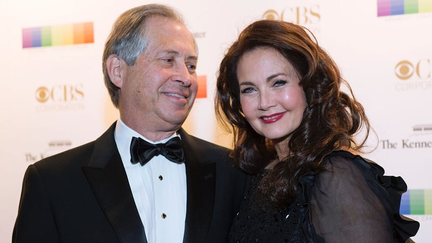 Robert Altman in a tuxedo looks lovingly at his wife Lynda Carter in a black dress