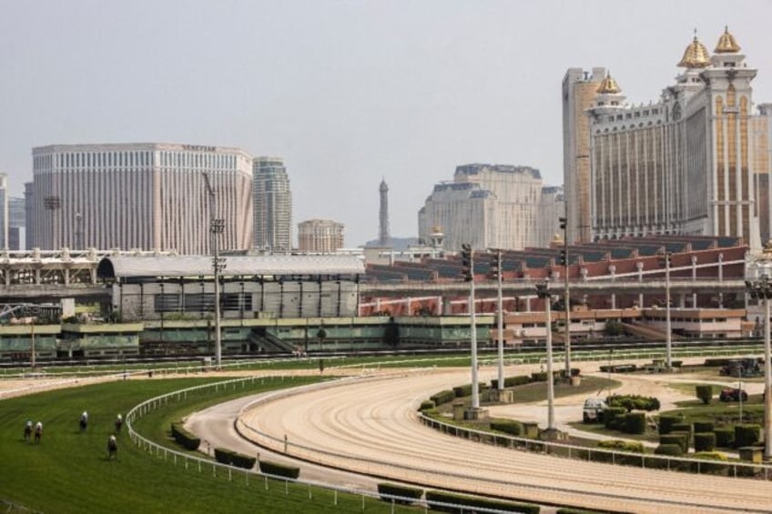 Horses race at one of the final meetings in Macau, with with glitzy casino resorts towerin