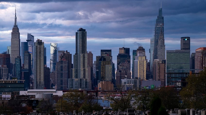 The sun sets behind the New York skyline