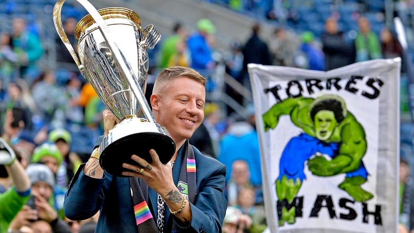 Macklemore holds a trophy