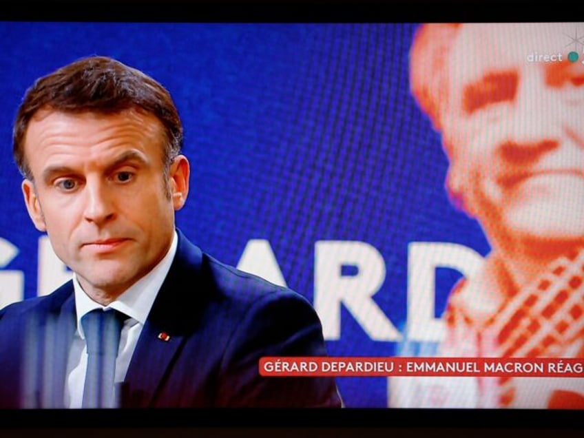 This photograph taken on December 20, 2023 shows a television screen broadcasting French TV channel France 5 as French President Emmanuel Macron speaks during an interview in the "C a vous" TV show, at the Elysee Presidential Palace, in Paris, following the approval of the law to control immigration, on …