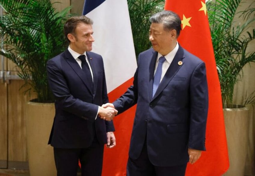 French President Emmanuel Macron (L) shakes hands with China's President Xi Jinping during