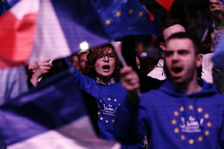 Supporters wave French and European flags as President Emmanuel Macron's centrist alliance