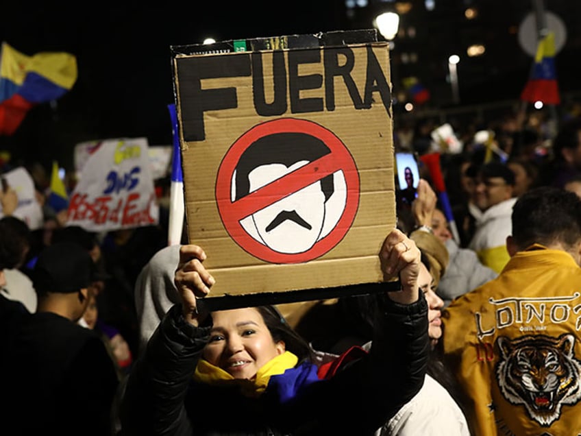 A woman holds a banner reading 'Fuera' in Spanish as Venezuelan expatriates protest the re-election of Nicolas Maduro in Santiago, Chile on August 03, 2024. Following the elections, which were widely criticized as fraudulent, Venezuelans took to the streets in cities around the world to express their rejection of the current president's regime. (Photo by Lucas Aguayo Araos/Anadolu via Getty Images)