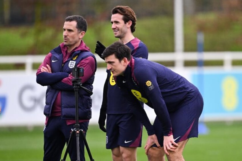 England's Harry Maguire (front R) looks at a smart phone as part of a team training sessio