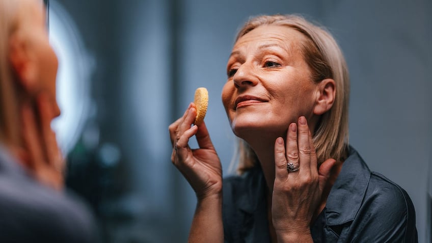 woman applying make up with a sponge