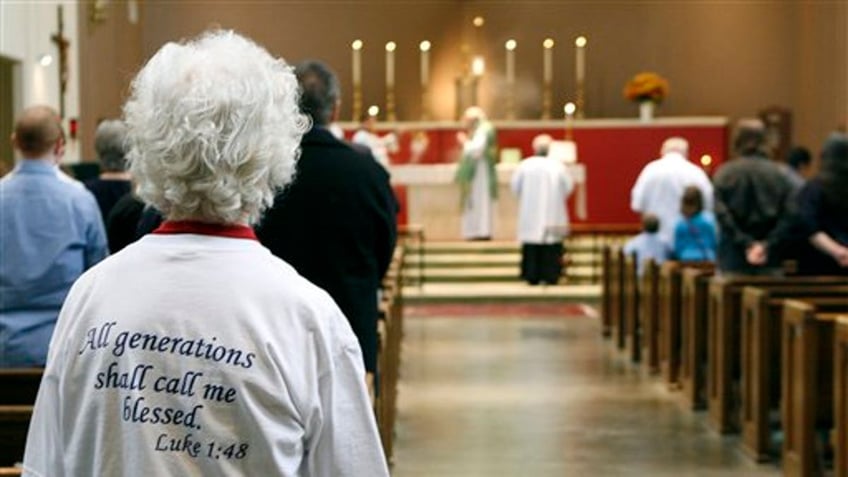 In this Sunday, Oct. 25, 2009 photo, Lavon Ferrell, left front, attends Sunday Mass at Saint Mary the Virgin Catholic Church in Arlington, Texas. The conservative church became a Roman Catholic church in 1994 after it left the Episcopal Church. (AP Photo/Amy Gutierrez)