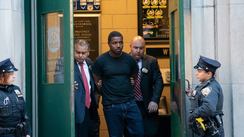 Jaheem Warren being led out of an NYPD building. 