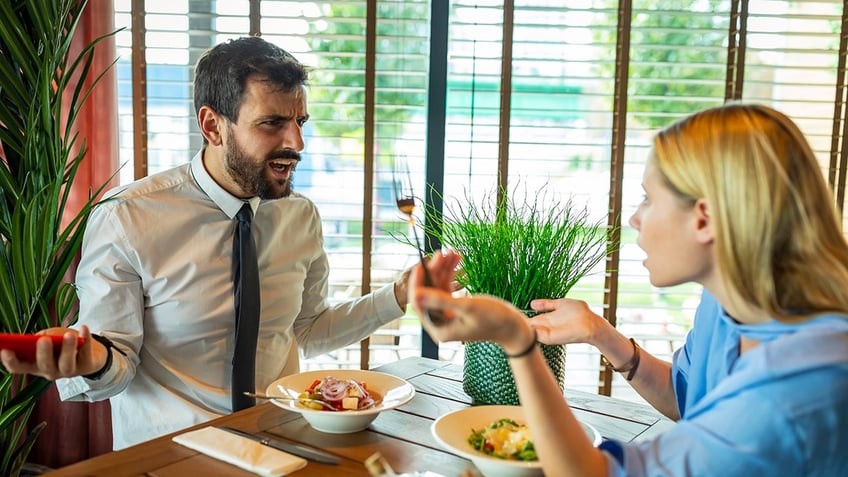 man upset with woman at meal