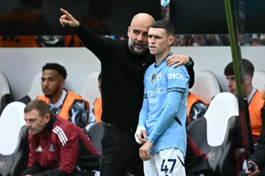 Manchester City manager Pep Guardiola speaks with Phil Foden