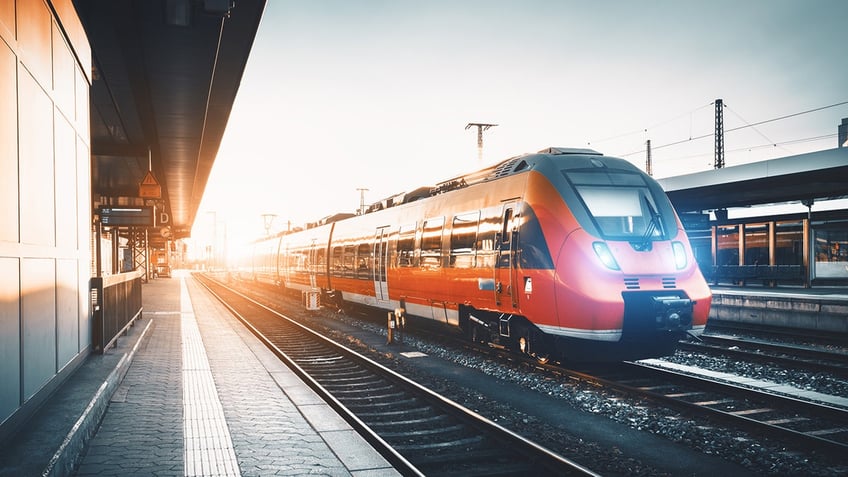 red commuter train on tracks