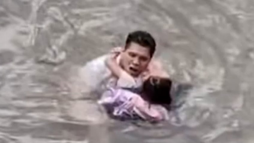 man jumps into fast flowing river to rescue little girl see the heroic moment