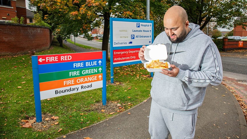 Man outside of NHS hospital holding food.