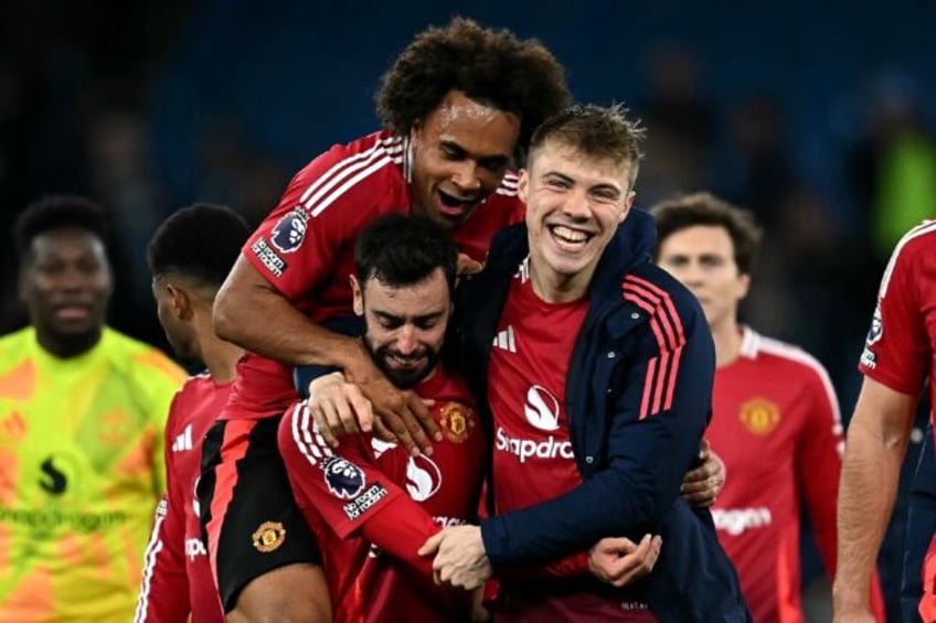 Manchester United players celebrate after a 2-1 victory against Manchester City at the Eti