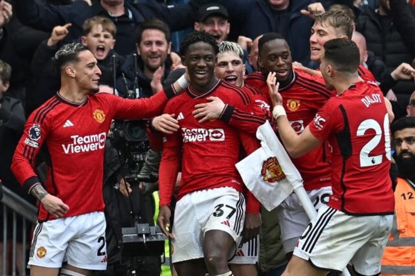 On target: Kobbie Mainoo (C) celebrates with teammates after scoring Manchester United's s