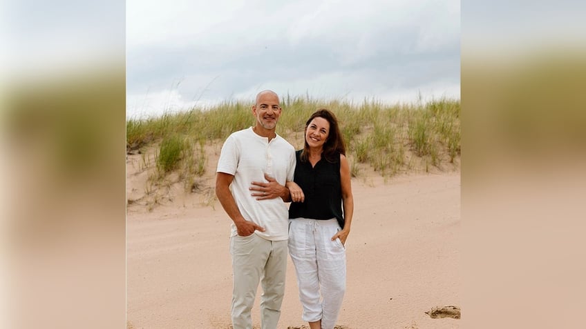 Matt Maclean with wife Beth, standing on beach.